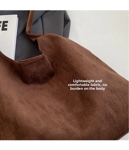 Detail shot of vintage dark brown faux suede tote bag with smooth leather strap