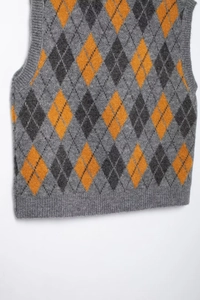 Detailed close-up of the ribbed hem and argyle knit pattern on the gray sweater vest