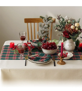 Festive table setting with red and green plaid runner and matching napkins for Christmas