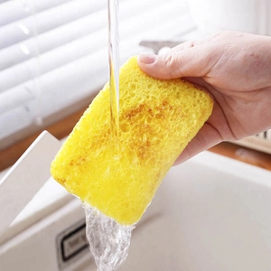 Absorbent yellow wood pulp cellulose sponge under running water for kitchen cleaning