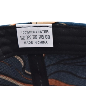 Macro view of care label inside the tie-dye baseball cap showing 100% polyester fabric