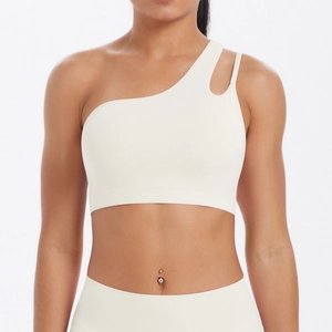 Close-up of asymmetrical off-white sports bra with shoulder cutout and matte texture