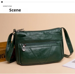 Détail du sac à bandoulière vert foncé à plusieurs fermetures éclair en cuir grainé