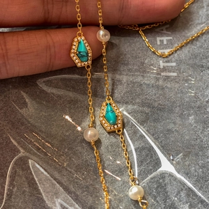 Detail of 18K gold-plated necklace with turquoise stones, pearls, and sparkling crystals