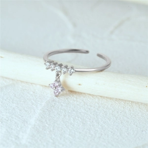 Detailed shot of S925 silver ring with five white diamonds and a pink floral charm
