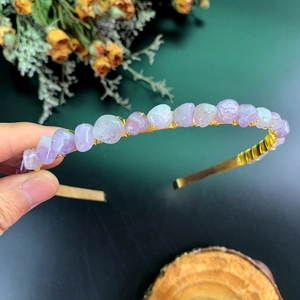 Macro shot of handmade crown headband with purple natural stones and golden wire winding