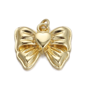 Detail of 18K gold plated bow and heart pendant showing shiny polished metal finish