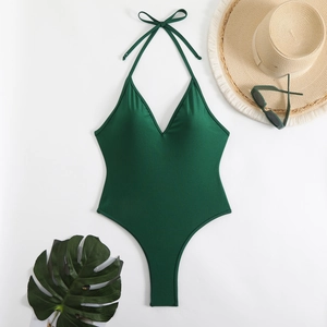 Deep green halter neck one-piece swimsuit with V-neck and resort style accessories