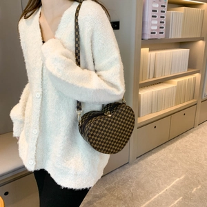 Dettaglio della borsa a cuore con monogramma vintage e chiusure lampo dorate lucide