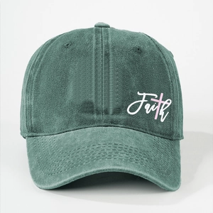 Close-up of washed dark green cotton baseball cap with Faith text and pink cross print