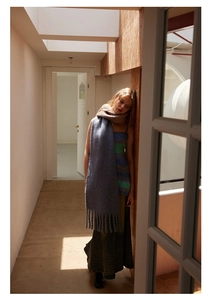 Artistic detail of a blue and brown gradient knit scarf with tassels in natural light