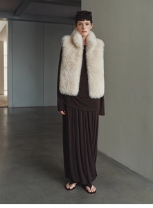 Close-up of a premium light beige faux fox fur cashmere vest on a model in a studio