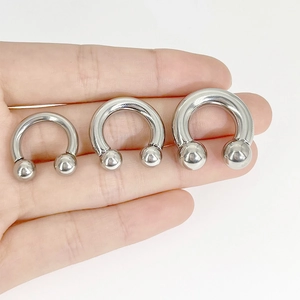 Hufeisenförmiges Körperschmuck-Set aus Edelstahl in drei Größen auf der Hand