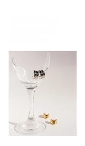 Artistic detail of gold and silver C-shaped minimalist hoop earrings on a broken glass
