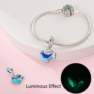 Vue détaillée d'un charm baleine lumineux sur bracelet argenté avec émail bleu brillant