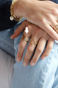Detailed shot of an irregular gold-plated titanium open ring on model's finger