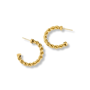 Close-up of golden 18K gold-plated C-shaped earrings with twisted metal texture