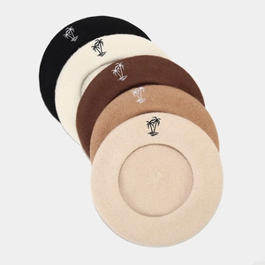 Detail of wool beret set featuring colorful options with minimalist palm tree embroidery