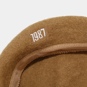 Brown wool beret with 1987 white embroidery, featuring premium stitching and texture