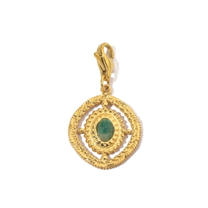 Close-up of vintage gold stainless steel charm with emerald green stone and lobster clasp