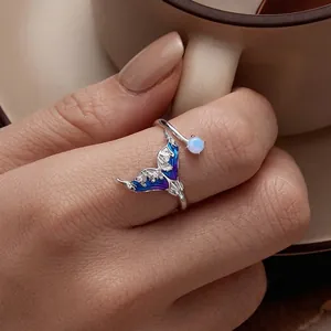 925 silver mermaid tail open ring with blue enamel and opal on a hand with coffee cup