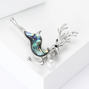 Elegant silver elk brooch with iridescent abalone shell and pearl on white stand