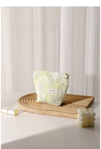 Close-up of floral jacquard cosmetic bag with golden flower zipper and brand label