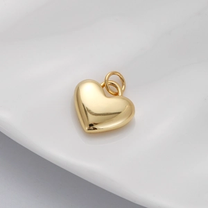 Close-up of a gold-plated heart pendant with Virgin Mary engraving and micro zircons