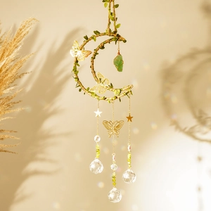 Detail of moon-shaped wind chime with green raw stone and golden butterfly accents