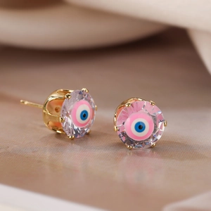 Macro shot of gold-plated evil eye stud earrings with zircon inlay and faceted detail