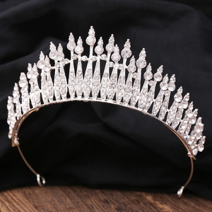 Detailed view of silver crystal tiara with sparkling rhinestones on dark fabric background