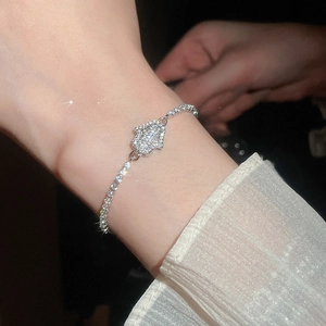 Macro shot of a silver Hamsa Hand bracelet with sparkling cubic zirconia on a wrist