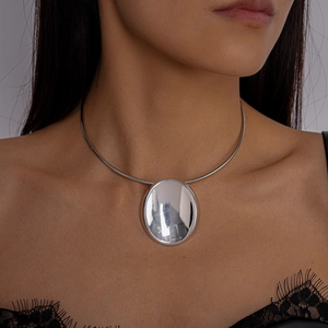 Detail eines silbernen Metall-Chokers mit großem ovalen Spiegelanhänger am Model getragen