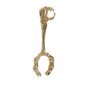 Detailed macro shot of a golden skeleton hand cigarette holder ring with metallic finish