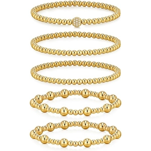 Set di cinque braccialetti a sfere dorate sovrapposti con dettagli in strass su sfondo bianco