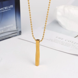 Detailed macro view of a twisted gold matte rectangular pendant with a beaded chain