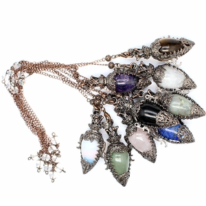 Macro detail of vintage bronze necklaces with hollow filigree crystal pendants