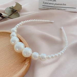 Close-up of white gradient pearls on an elegant headband with soft protective end caps