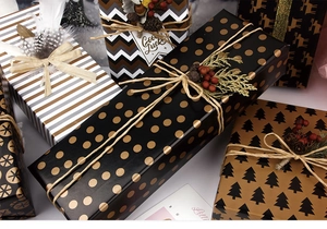 Assorted gift boxes with gold polka dots, stripes and Christmas tree pattern wrapping paper