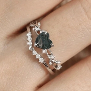 Detail of S925 sterling silver ring set featuring heart-shaped moss agate on model's hand