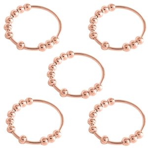 Detail view of five rose gold anxiety relief rings with rotatable beads on white backdrop