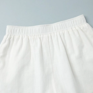 Détail du short en lin blanc avec taille élastique et texture de tissu naturelle et légère