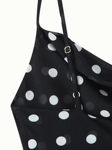 Detailed view of adjustable spaghetti straps and ruffles on a polka dot dress