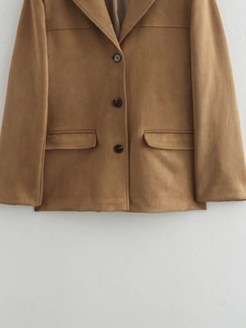 Détail d'un blazer marron en similicuir avec revers classiques et poches à rabat