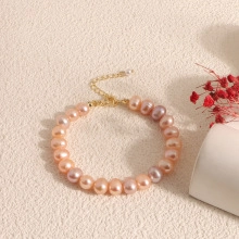 Close-up of pink and purple baroque pearl bracelet with gold adjustable chain clasp