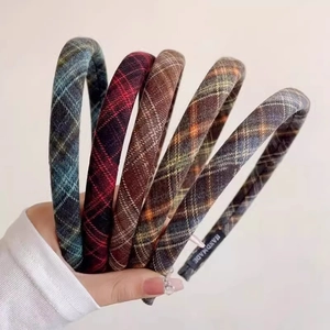 Detail shot of five assorted plaid fabric headbands with handmade labels and patterns