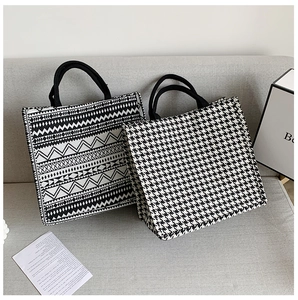 Detail of leopard print and geometric patterned tote bags with rope handles on sofa