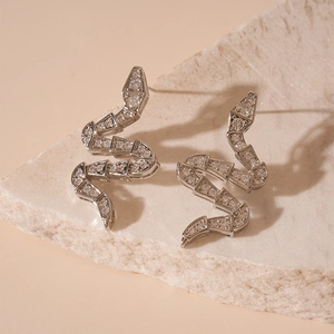 Detailed macro shot of silver snake-shaped earrings with zircon inlay on stone