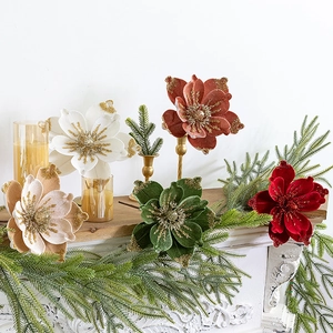 Velvet Christmas artificial flowers with gold glitter edge on white fireplace mantel