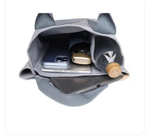 Top view of gray canvas handbag with compartments showing storage for tablet and water bottle
